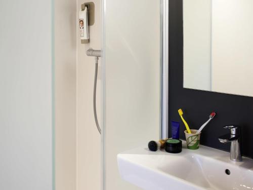a bathroom with a sink and a mirror at ibis budget Amsterdam Airport in Badhoevedorp
