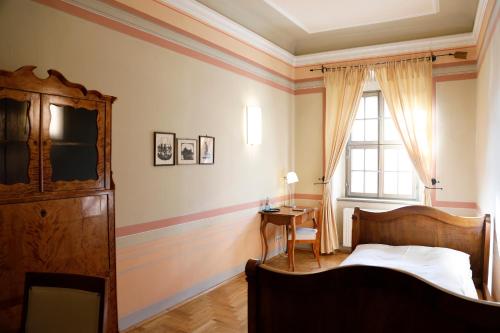a bedroom with a bed and a table and a window at Gästehaus im Flüsterbogen in Görlitz