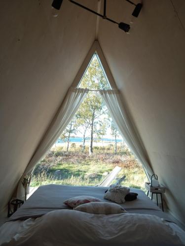 a bed in a tent with a large window at Glamping hut with panorama view in Björköby