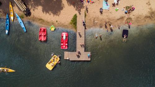 a group of people on a beach with boats in the water at Nad Zalewem - pokoje przy plaży in Kobyla Góra
