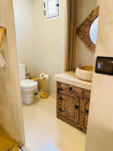 a bathroom with a toilet and a sink at ChariF Luxury Camp in Rissani