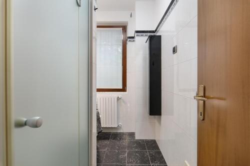 a bathroom with white walls and a black tile floor at Villa In Saronno in Saronno