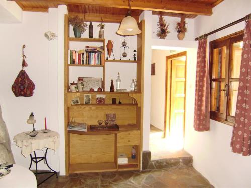 Emilio's House في Agia Paraskevi: غرفة مع رف كتاب وطاولة
