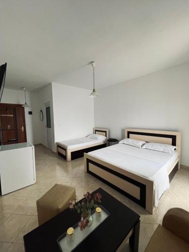 ein Schlafzimmer mit zwei Betten und ein Wohnzimmer in der Unterkunft Sunset Dream Guesthouse in Himarë
