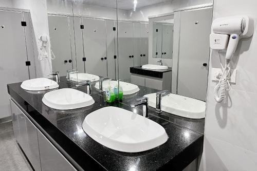 a bathroom with three sinks and a hair dryer at Hanoi Backpackers Lodge in Hanoi