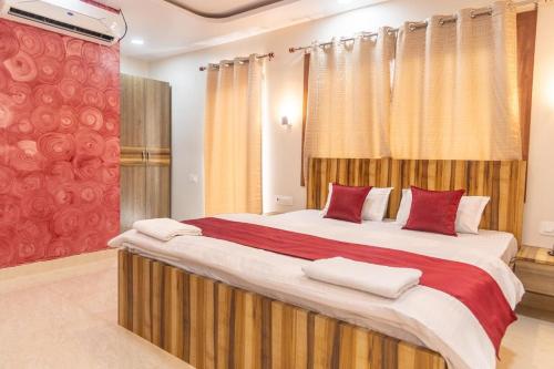 a bedroom with a large bed with red pillows at Raghuvansh Hotel in Gaya