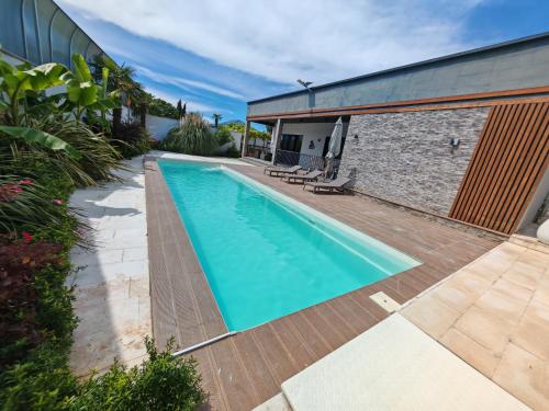 a swimming pool with a wooden deck next to a building at Sunnyside cottage Bilgah in Bilgah
