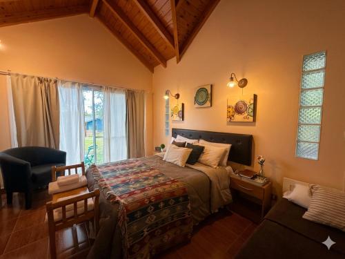 a bedroom with a bed and a chair and a window at Flor de Lis Casas de Campo in Los Cocos