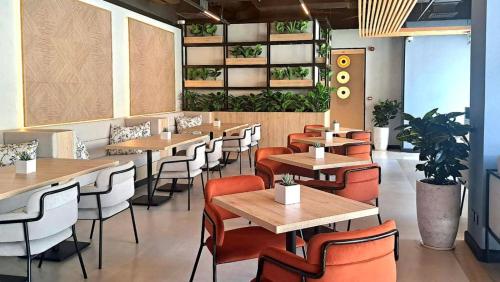 a restaurant with wooden tables and chairs and plants at Barceló Residences Dubai Marina in Dubai