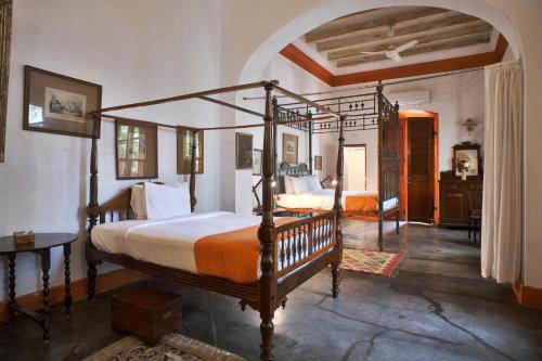 a bedroom with a four poster bed in a room at Dune de L'orient in Pondicherry