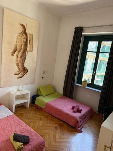 a room with two beds and a painting on the wall at Centro - doppia in casa d'artista in Turin