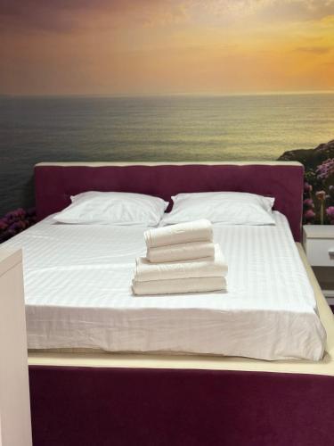 a bed with white sheets and pillows on it at Vila cu Ciubar & Jacuzzi - Sunset Hill House in Cuvin