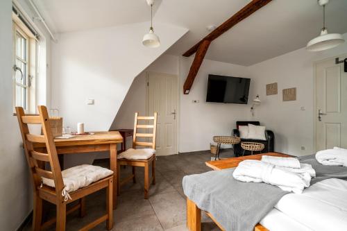a room with two beds and a table and chairs at Hotel Bolter Mühle - DZ Mohnbuchte in Rechlin