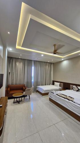 a hotel room with two beds and a couch at Hotel Akshara Inn in Nasīrābād