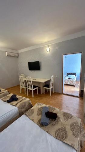 a room with a table and chairs and a television at Garden Sheki Hotel in Sheki