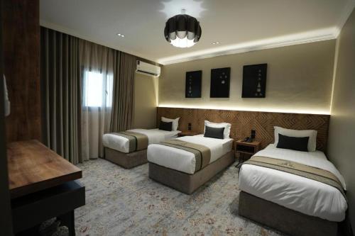 a hotel room with two beds and a desk at فندق اناف in Medina