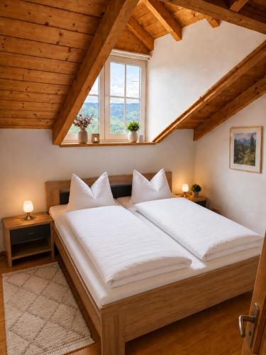 a large bed in a room with wooden ceilings at Helle Ferienwohnung im Bayerischen Wald mit Balkon, Garten & viel Platz für 4 in Mauth