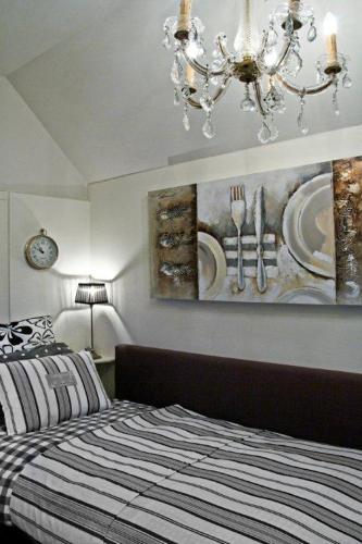 a bedroom with a bed and a chandelier at Het Woonrijk in Bennekom