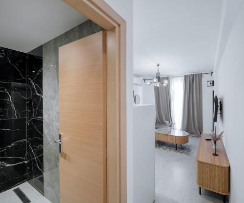 a bathroom with a wooden door and a bedroom at Ambra Luxury Suite 18 in Kallithea Halkidikis