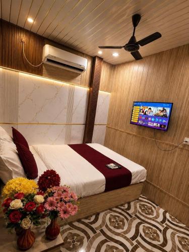 a bedroom with a bed and a flat screen tv at Hotel Akasa View in Mumbai