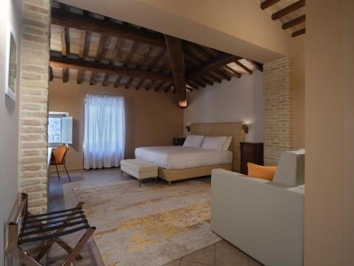 a bedroom with a bed and a couch in a room at Palazzo Brunamonti Boutique Hotel in Bevagna
