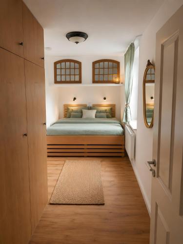 a bedroom with a bed with green sheets and a mirror at Villa Verde in Flensburg