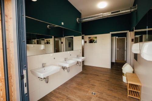 a bathroom with three sinks and a green wall at NUR Camping Stellplatz OHNE Zelt oder Wohnwagen sowie Schlaffässer in Groß Kordshagen