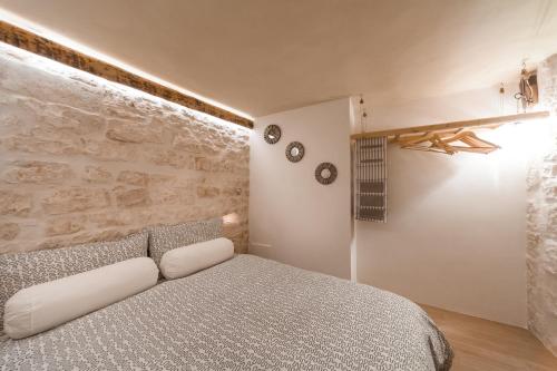 een slaapkamer met een bed en twee klokken aan de muur bij Casa20 in Cisternino