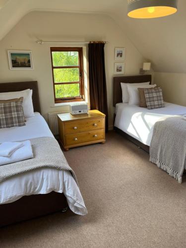 a bedroom with two beds and a window at The Hayloft, Wonderful Riverside Accommodation in Bodenham