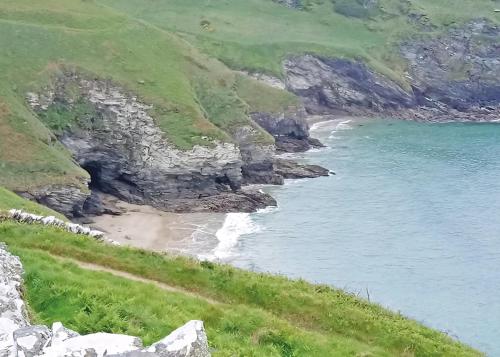 a view of a beach with the ocean at Bossiney Bay in Tintagel