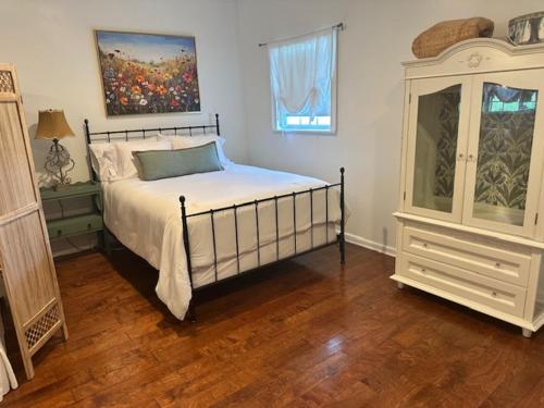 a bedroom with a bed and a painting on the wall at Cozy Luxury Cottage in Alachua