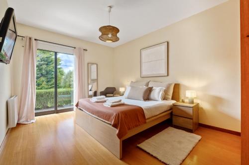 a bedroom with a bed and a large window at Sweet Orchard Escape - By Wehost in Porto Moniz