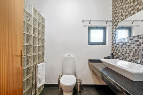 a bathroom with a toilet and a sink at Sweet Orchard Escape - By Wehost in Porto Moniz