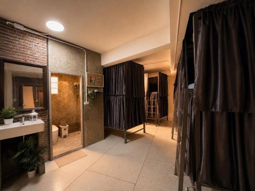 a bathroom with a shower and a sink and a toilet at TUKTUK Home in Samphanthawong