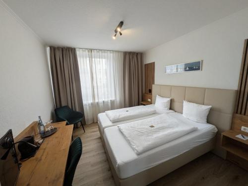 a hotel room with a bed and a desk at Hotel Flensburger Hof in Flensburg