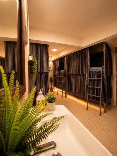 a bathroom with a sink and a bath tub with curtains at TUKTUK Home in Samphanthawong