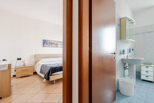 a bedroom with a bed and a bathroom with a sink at Appartamento Manerbio in Manerbio