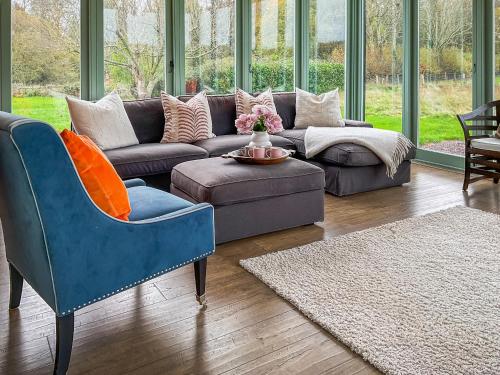 a living room with a couch and a blue chair at Smallbrook Cottage - Uk50922 in Salisbury