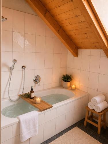 a bathroom with a tub with candles in it at Helle Ferienwohnung im Bayerischen Wald mit Balkon, Garten & viel Platz für 4 in Mauth