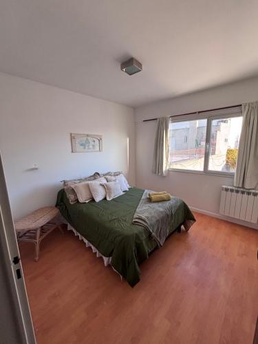 a bedroom with a bed and a large window at La Serenité en Puerto Madryn in Puerto Madryn
