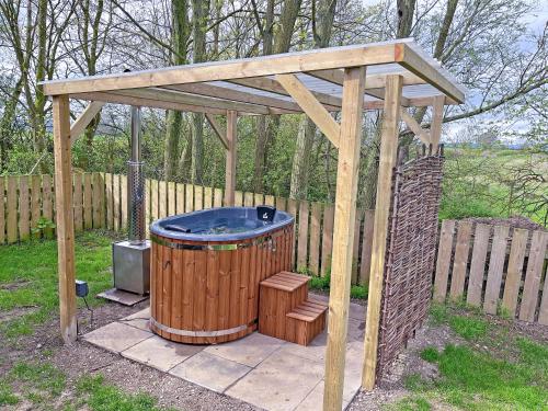 a wooden gazebo with a hot tub in a yard at The Rams Rest - Uk48823 in Kirby Misperton