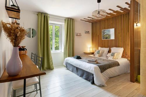 a bedroom with a bed and a table and a window at Le Clos D'audio in Riols