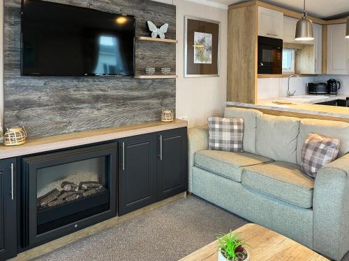 ein Wohnzimmer mit Kamin und Flachbildfernseher in der Unterkunft Maple 8 in Filey