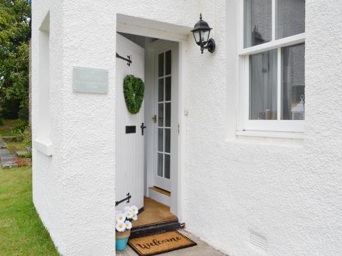 a white house with a white door and a window at The Old School House Cottage in Coupar Angus