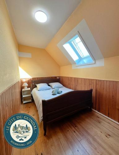 a bedroom with a bed with a skylight at Le Gite Zelya in Bourbourg