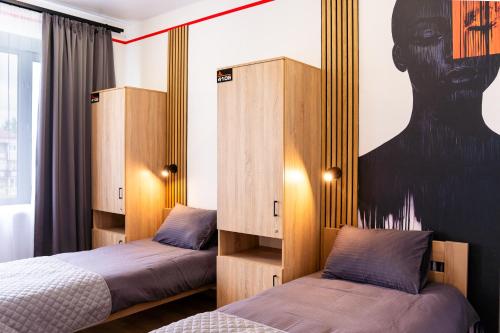a bedroom with two beds and a poster of a woman at Готель Бутік Сіті in Kropyvnytskyi