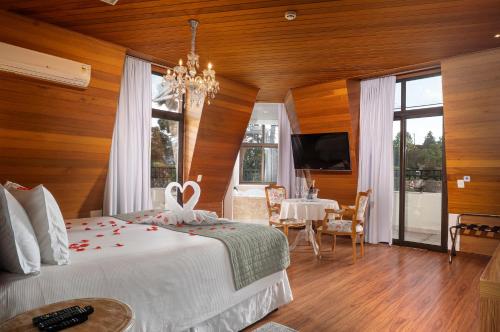 a bedroom with a bed and a dining room with a table at Pousada Luis XV in Campos do Jordão