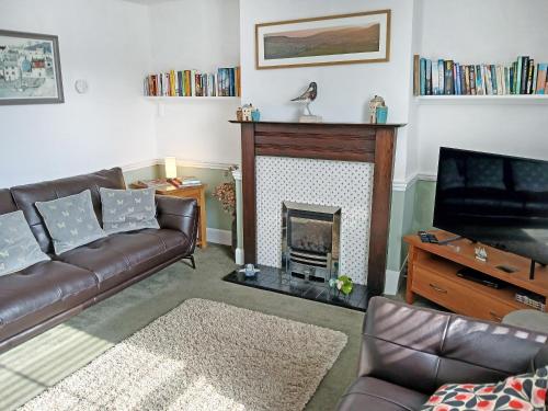 a living room with a couch and a fireplace at Old Town Cottage in Sidmouth