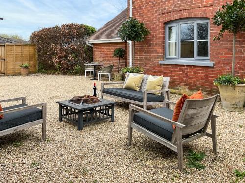 a patio with chairs and a table with a bottle of wine at Elm Tree House - Uk51762 in Landford