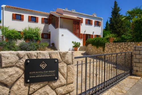 a house with a sign in front of a stone wall at Villa San Vista with pool in Sveti Vid-Miholjice